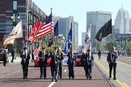 Veterans holding various flags at Veterans Day Parade