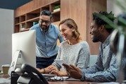 Three people looking at something on a computer