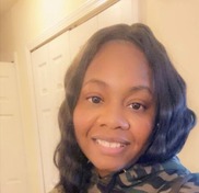 Talitha Heard smiling while standing in front of a closet