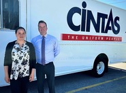 Cintas staff in front of bus with their logo on it