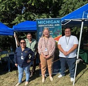 AFLS staff standing outside in front of an AFLS banner
