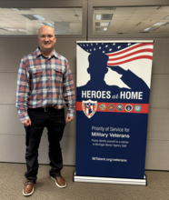 Calvin standing next to VES banner