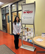 Alondra standing by a Michigan Works! banner