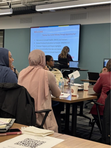 From the back view of people watching the Race to Talent presentation