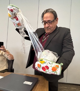 Picture of Gerardo Aranda playing the Saran Wrap Game designed to encourage innovation and problem-solving under challenging conditions.