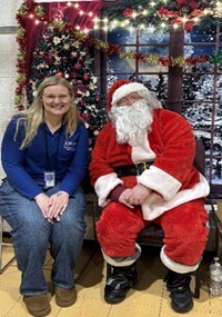 Picture of Abigail Frost sitting with Santa at Michigan Resource Posada Event.