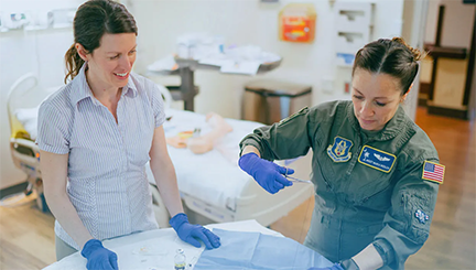 Military member learning healthcare job skills from instructor