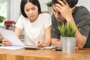 Two people anxiously calculating something while holding a bill