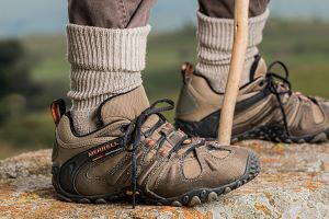 Close up of someone's hiking boots with a walking stick between them