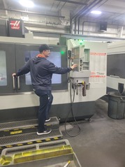 Young man with back to camera operating a machine