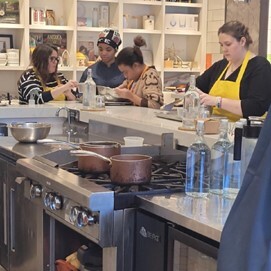 Group of students prepping food in a commercial kitchen