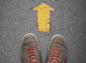 Booted feet standing behind yellow arrow on ground