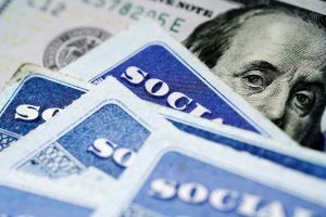 Social Security Cards with US One Hundred Dollar Bill in the background