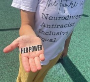 Close up of the words "Her Power" placed in a girl's open hand