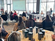 Room of people sitting at round tables during Race to Talent event