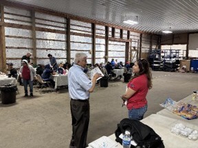 Ruben speaking with a worker while others are at tables in the background
