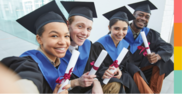 Diverse group of young adults wearing a cap and gown and holding up rolled diplomas