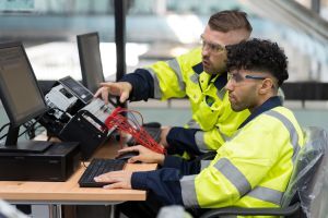 Two male engineers using desktop computer training Programmable logic controller