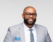 Will Connors, a Black man in a grey suit and glasses