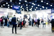 Blurred exhibition event in hall with many people on background