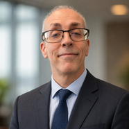SK Dixon, a white man in glasses wearing a navy suit