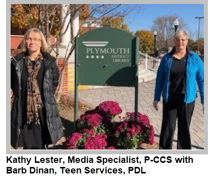 Kathy Lester and Barb Dinan by the library sign
