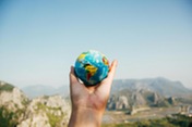 hand holding a tiny earth ball