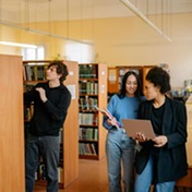 three people in a library talking