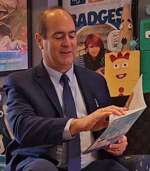 Clerk Forlini reading a book to the children during National Reading Month