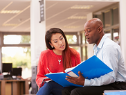 Two educators look at a resource