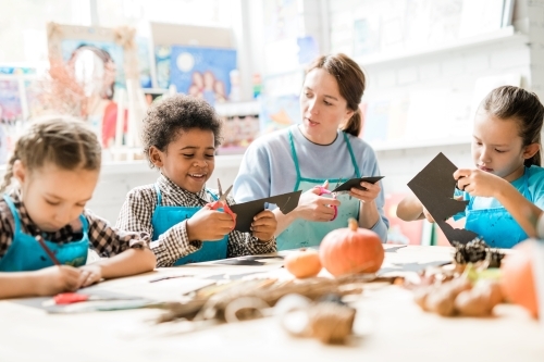 An elementary school teacher is making fall themed crafts with her students.
