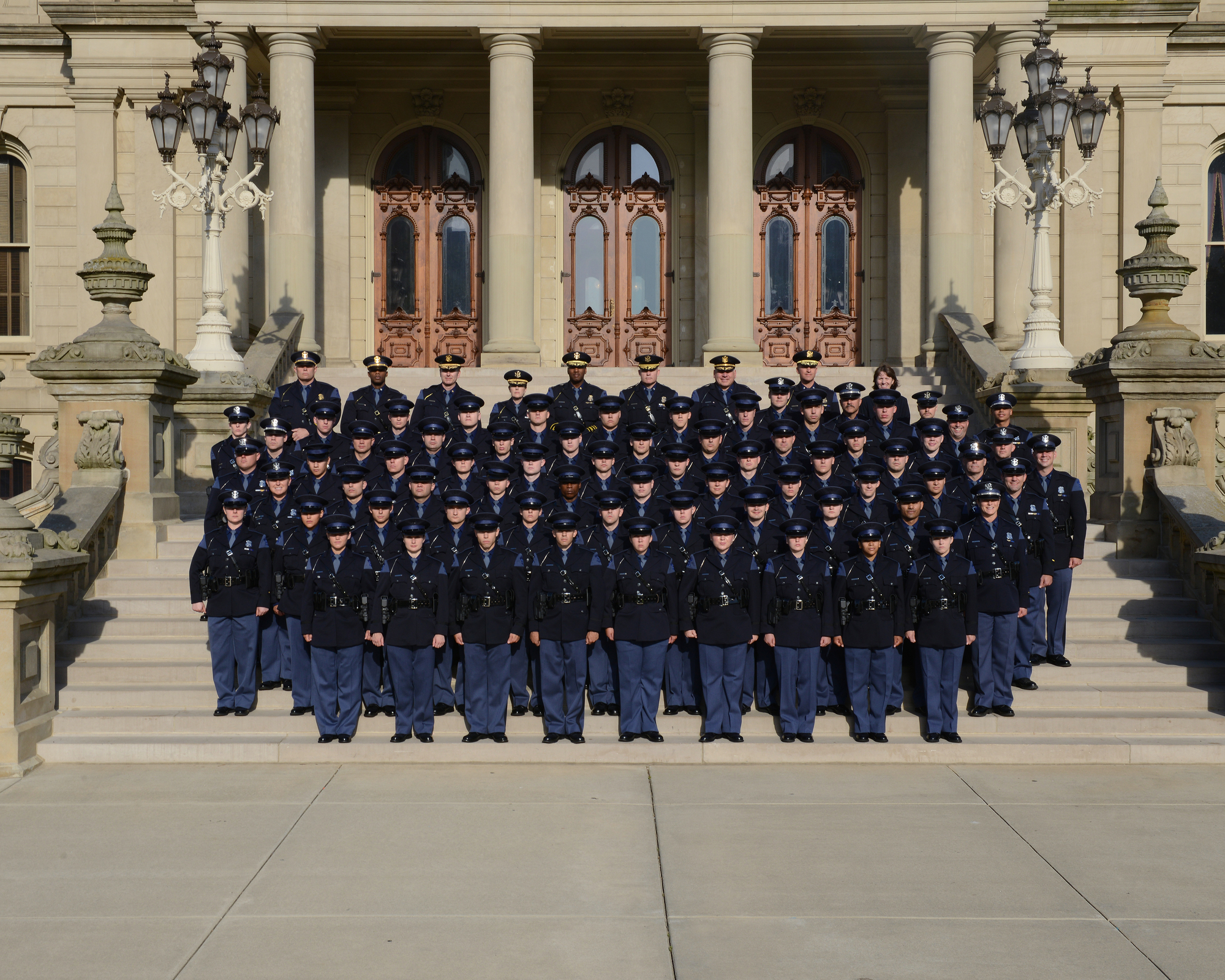 group photo including graduates of the 145th Trooper Recruit School standing on the steps of the Capitol Building