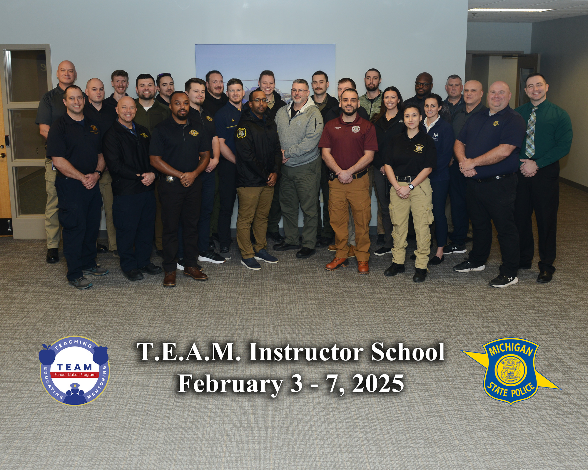 Graduates of TEAM school standing inside a classroom in a group