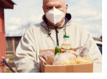 Elderly man holding a box of food