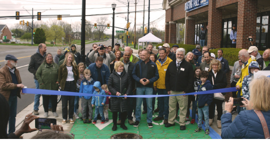 A large group of people gathered for the ribbon cutting of the The Michigan Air Line Trail