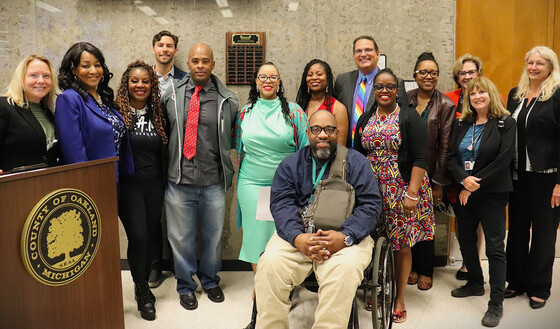 Commissioners unveil Black Excellence Award plaque in the lobby of the auditorium.