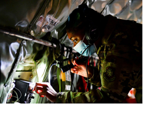 Military person examining machinery