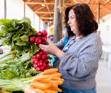 Woman buys radishes at farmers market