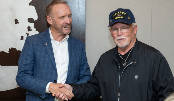 Dave shakes hands with a Navy veteran and Oakland County employee.