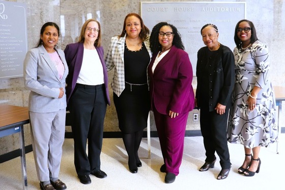 Six women stand together in the lobby of the Oakland County Board of Commissioners Auditorium