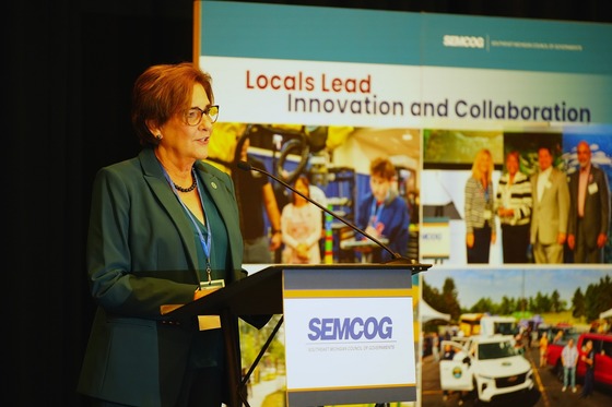 Commissioner Markham speaking in front of a podium