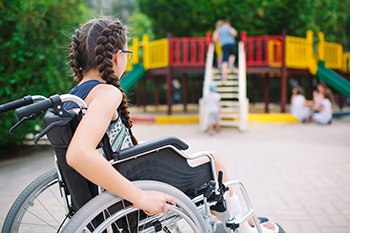 Child in wheelchair looking at a playground
