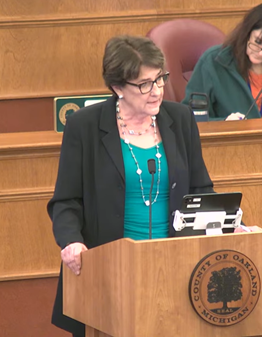 Commissioner Gwen Markham, chair of the Finance Committee, addresses commissioners in the auditorium