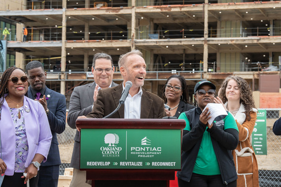 County Executive Dave Coulter speaks at Pontiac redevelopment press conference with local officials behind him.