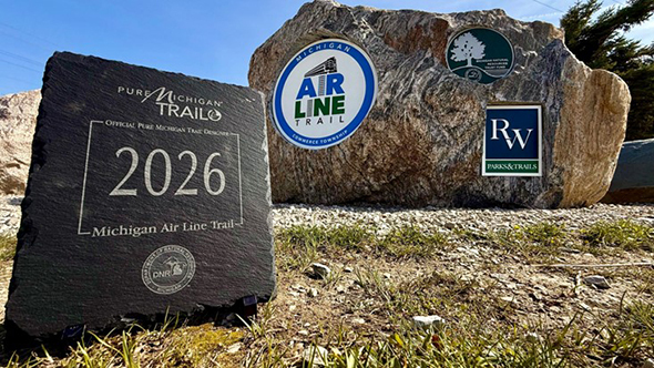 A plaque designating the Michigan Air Line Trail as a Pure Michigan Trail. 
