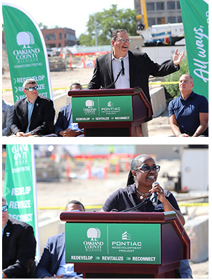 Chair Woodward and Commissioner Powell standing at a podium outside the Pontiac Redevelopment site on a sunny day.