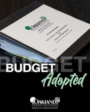 Close up of the large Oakland County budget binder, a thick stack of tabbed documents