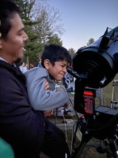 Kid looking through telescope