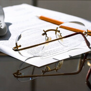 Reading glasses on a piece of paper with a pencil