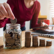 Jar with coins and stacks of quarters next to it